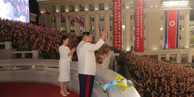 In this photo provided by the North Korean government, North Korean leader Kim Jong Un, with his wife Ri Sol Ju, acknowledges the audience during a military parade to mark the 90th anniversary of North Korea's army at the Kim Il Sung Square in Pyongyang, North Korea Monday, April 25, 2022. (Korean Central News Agency/Korea News Service via AP)