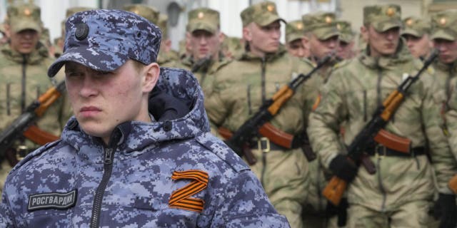 A soldier of Russian Rosguardia (National Guard) with an attached letter Z, which has become a symbol of the Russian military, stands guard.