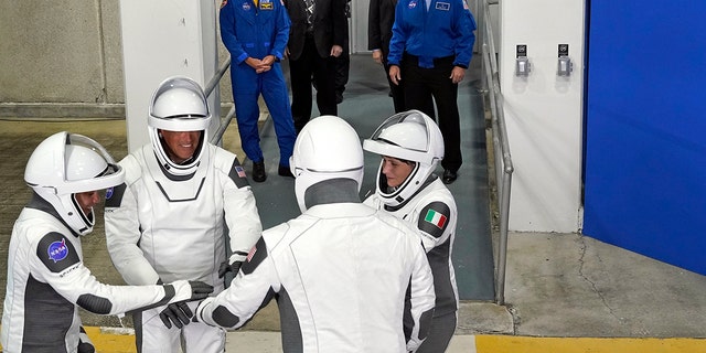 SpaceX Crew-4 宇航员（左）、任务专家 Jessica Watkins、飞行员 Bob Hines、指挥官 Kjell Lindgren 和来自意大利的任务专家 ESA 宇航员 Samantha Cristoforetti，在离开运营大楼和推进器后聚集在一起，准备飞往发射场。39- 2022 年 4 月 27 日，星期三，在佛罗里达州卡纳维拉尔角的肯尼迪航天中心。