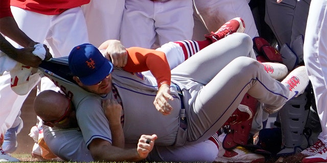 New York Mets' Pete Alonso is taken to the ground by St. Louis Cardinals first base coach Stubby Clapp during an eighth-inning scuffle Wednesday, April 27, 2022, in St. Louis.