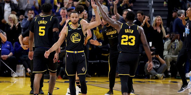 تهنئة حارس Golden State Warriors ستيفن كاري (30) من قبل Draymond Green (23) خلال مهلة في النصف الأول من اللعبة 5 من سلسلة NBA لكرة السلة للفريق في الجولة الأولى ضد Denver Nuggets في سان فرانسيسكو ، الأربعاء 27 أبريل . ، 2022.