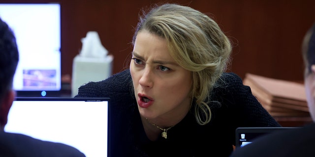 Actor Amber Heard speaks to her legal team in the courtroom at the Fairfax County Circuit Court in Fairfax, Va., Thursday, April 28, 2022. 