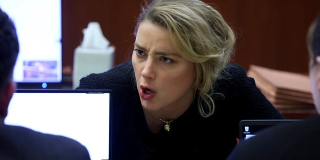 Actor Amber Heard speaks to her legal team in the courtroom at the Fairfax County Circuit Court in Fairfax, Va., Thursday, April 28, 2022.