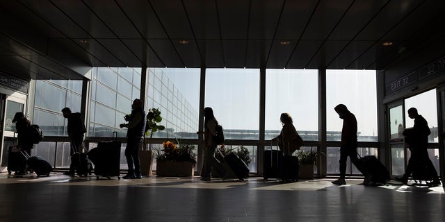 Travelers walk with their luggage in the Ben Gurion Airport near Tel Aviv, Israel, on Nov. 28, 2021. 