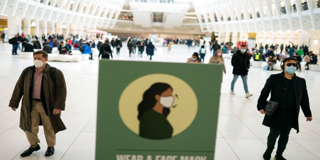 Mass transit riders wear masks as they commute in the financial district of lower Manhattan, Tuesday, April 19, 2022, in New York.