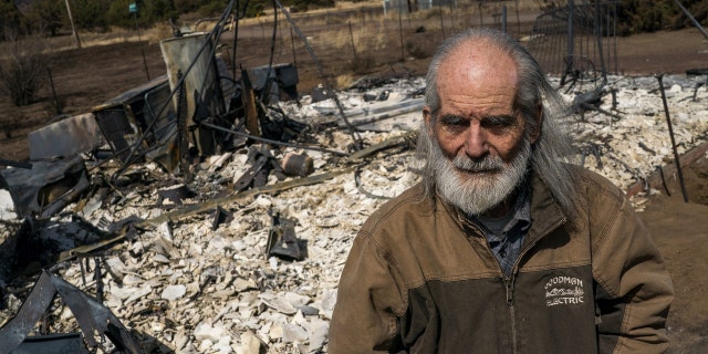 David Barthman, 74, stands in front of his completely burned down guest home as residents were allowed to return to their homes after a wildfire burned through parts near Highway 89 in northeast Flagstaff, Arizona, U.S. April 24, 2022. Picture taken April 24, 2022.