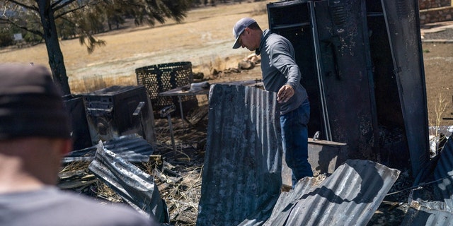 Travis Hopkins looks for salvageable objects at a historic barn that was burned down at his home after a wildfire burned through parts near Highway 89 in northeast Flagstaff, Arizona, U.S. April 24, 2022. Picture taken April 24, 2022. 