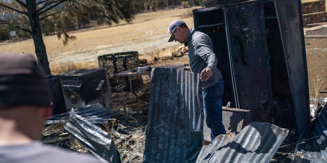 Travis Hopkins looks for salvageable objects at a historic barn that was burned down at his home after a wildfire burned through parts near Highway 89 in northeast Flagstaff, Arizona, U.S. April 24, 2022. Picture taken April 24, 2022.