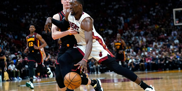 Miami Heat center Bam Adebayo, right, drives to the basket as Atlanta Hawks guard Kevin Huerter defends during the second half of an NBA basketball game Friday, April 8, 2022, in Miami. The Heat won 113-109.