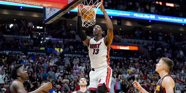 Miami Heat center Bam Adebayo (13) dunks over Atlanta Hawks forward Danilo Gallinari (8) and guard Bogdan Bogdanovic, right, during the second half of an NBA basketball game Friday, April 8, 2022, in Miami. The Heat won 113-109.