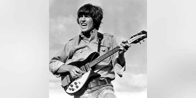 Beatle George Harrison is shown playing the guitar in a scene from the Beatles movie "Help!" on location in the Bahamas in 1965. 