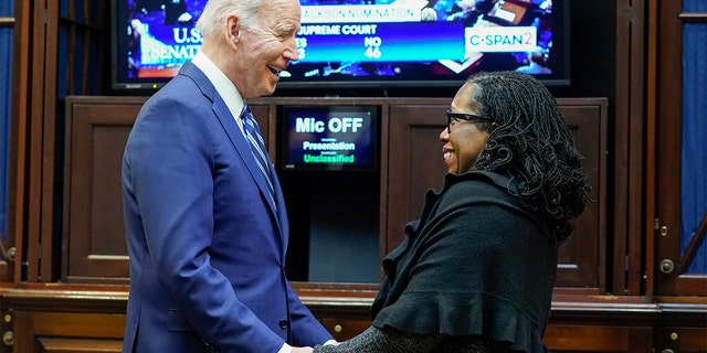 President Biden holds hands with Supreme Court nominee Judge Ketanji Brown Jackson as they watch the Senate vote on her confirmation from the Roosevelt Room of the White House in Washington, Thursday, April 7, 2022.