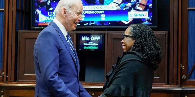 President Biden holds hands with Supreme Court nominee Judge Ketanji Brown Jackson as they watch the Senate vote on her confirmation from the Roosevelt Room of the White House in Washington, Thursday, April 7, 2022.