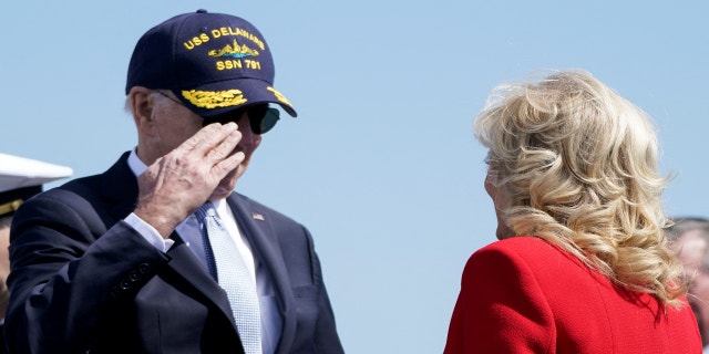 President Biden salutes first lady Jill Biden during a commemorative commissioning ceremony for the USS Delaware nuclear submarine at the Port of Wilmington, Del., April 2, 2022.
