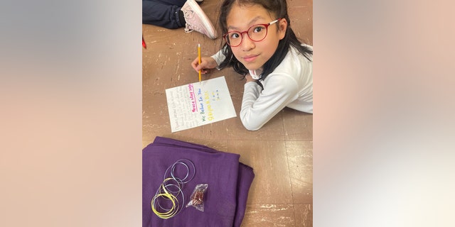 Estudiantes escribiendo notas escritas a mano para personas que necesitan Mantas de esperanza.