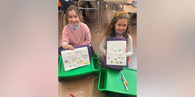 Estudiantes escribiendo notas escritas a mano para personas que necesitan Mantas de esperanza.