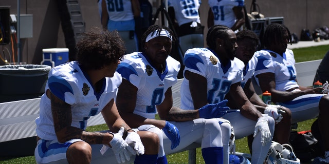 New Orleans Breakers players on the sideline during a scrimmage.