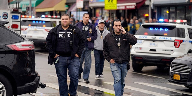 New York City Police Department personnel gather at the entrance to a subway stop in the Brooklyn borough of New York, Tuesday, April 12, 2022. 