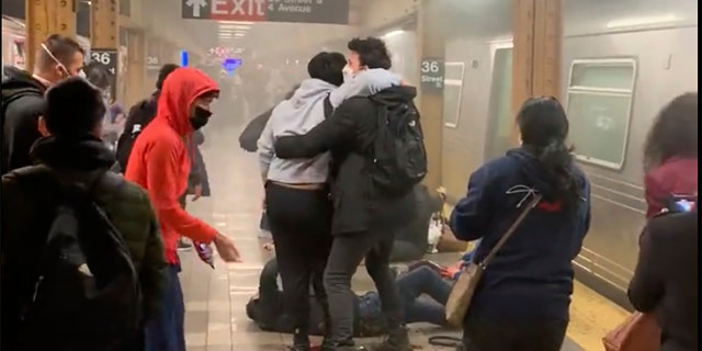 This photo provided by Will B Wylde, a person is aided outside a subway car in the Brooklyn borough of New York, Tuesday, April 12, 2022. 