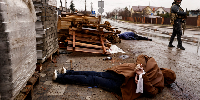 A body with hands bound by white cloth, who according to residents was shot by Russian soldiers, lies in the street in Bucha, Ukraine, on Sunday.