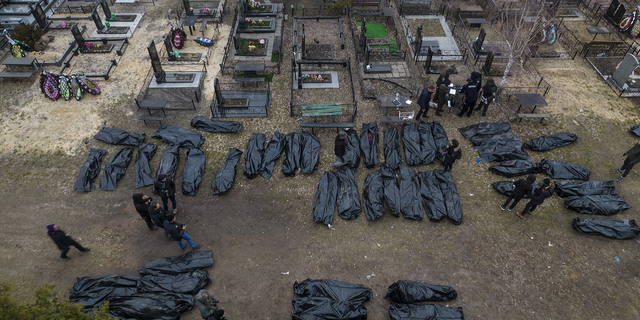 AVERTISSEMENT : IMAGE GRAPHIQUE : Les policiers travaillent sur le processus d'identification suite au meurtre de civils à Bucha, avant d'envoyer les corps à la morgue, à la périphérie de Kiev, en Ukraine, mercredi.