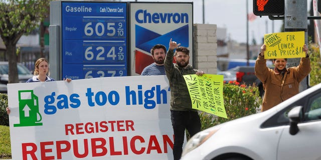 Activistas republicanos llaman la atención de los conductores mientras trabajan para registrar votantes para su partido en una gasolinera en Garden Grove, California, el 29 de marzo de 2022.