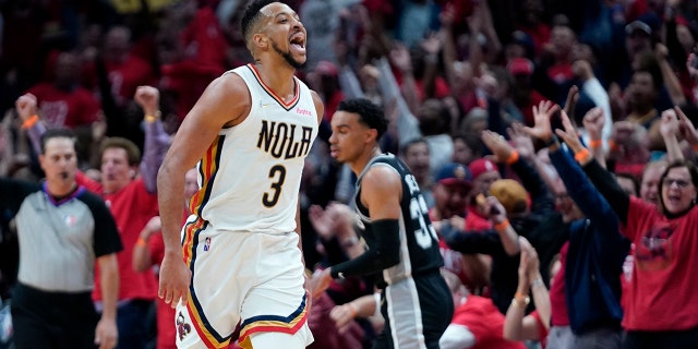 New Orleans Pelicans guard CJ McCollum (3) reacts with the crowd after scoring a 3-point basket in the first half of an NBA play-in basketball game against the San Antonio Spurs in New Orleans, mercoledì, aprile 13, 2022.