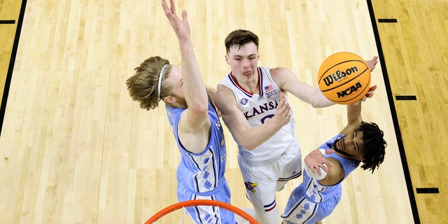 Christian Braun #2 of the Kansas Jayhawks drives to the basket against Brady Manek #45 and R.J. Davis #4 of the North Carolina Tar Heels during the first half of the 2022 NCAA Men's Basketball Tournament National Championship game at Caesars Superdome on April 04, 2022 in New Orleans, Louisiana.