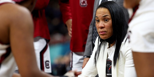 Head coach Dawn Staley of the South Carolina Gamecocks talks with her team during a timeout in the third quarter against the Louisville Cardinals during the 2022 NCAA Women's Final Four semifinal game at Target Center on April 01, 2022 in Minneapolis, Minnesota.