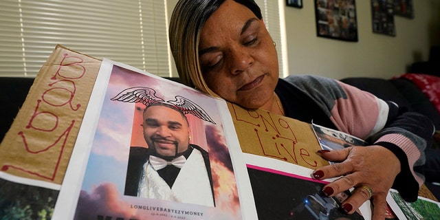 Penelope Scott sostiene una colección de fotos familiares, incluida una de su hijo, De'vazia Turner, una de las víctimas de un tiroteo masivo, durante una entrevista con The Associate Press en Elk Grove, California, el lunes 4 de abril de 2022. Varias personas murieron y resultaron heridas en el tiroteo un día antes. 