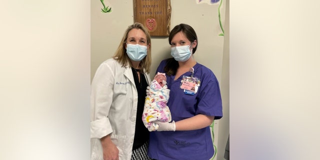 Dr. Ann Heerens (left) and Stefanie Martin, RN (right) are seen holding baby Grace.