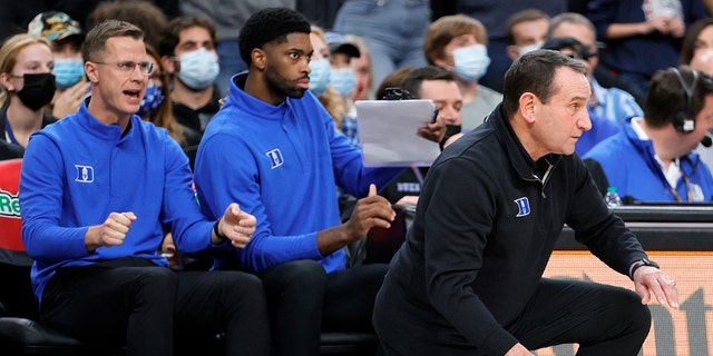 Associate head coach Jon Scheyer and director of player development Amile Jefferson of the Duke Blue Devils look on as head coach Mike Krzyzewski of the Blue Devils reacts during the Continental Tire Challenge against the Gonzaga Bulldogs at T-Mobile Arena on November 26, 2021 in Las Vegas, Nevada. The Blue Devils defeated the Bulldogs 84-81. 