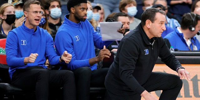 Associate head coach Jon Scheyer and director of player development Amile Jefferson of the Duke Blue Devils look on as head coach Mike Krzyzewski of the Blue Devils reacts during the Continental Tire Challenge against the Gonzaga Bulldogs at T-Mobile Arena on November 26, 2021 in Las Vegas, Nevada. The Blue Devils defeated the Bulldogs 84-81.