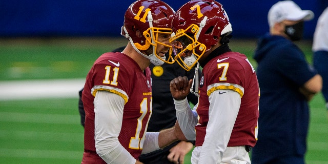 Washington Football Team quarterbacks Dwayne Haskins, right, and Alex Smith warm up before the game against the Dallas Cowboys at AT&T Stadium in Arlington, Texas, on Nov. 26, 2020.