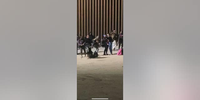 Migrants are pictured taking selfies at the border. (Houston Keene/Fox News Digital)