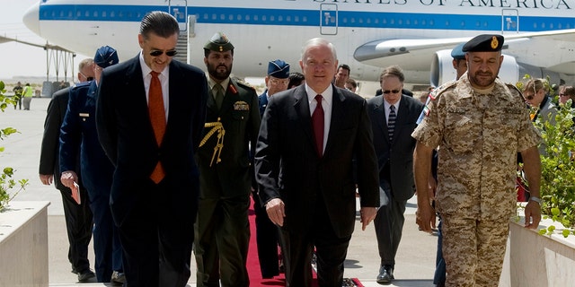 Defense Secretary Robert Gates walks with U.S. Ambassador to the UAE Richard Olson and others at the Al-Dhafra Air Base in Abu Dhabi, March 11, 2010.