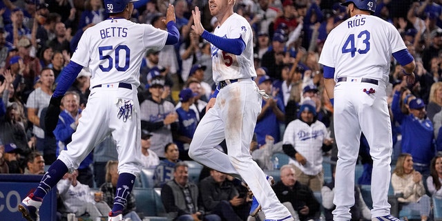 Freddie Freeman (center) of the Los Angeles Dodgers by Mookie Betts (left) and Edwin Rios after scoring on Trea Turner's double in the fourth inning of a baseball game against the Atlanta Braves in Los Angeles on Monday, April 18, 2022. Blessed. Angeles.