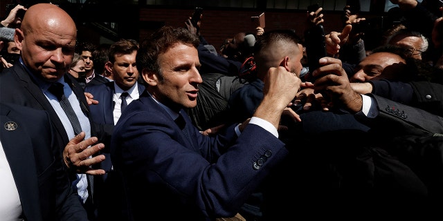 De pas herkozen Franse president Emmanuel Macron ontmoet bewoners op het marktplein van Saint-Christophe in Cergy, een voorstad van Parijs, woensdag 27 april 2022. 