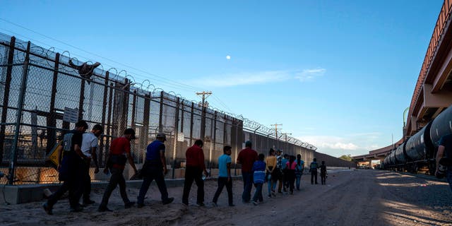 Migrants, mostly from Central America, queue to board a van which will take them to a processing center, on May 16, 2019, in El Paso, Texas.