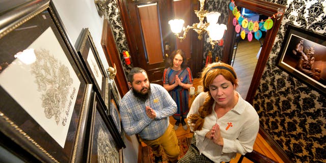 The cast members of the Hell House  Mercy Maelica, Cameron Willson (L) and Joy Davenport (C) pose for a photo at the Satanic Temple where a "Hell House" is being held in Salem, Massachusett on Oct. 8, 2019.