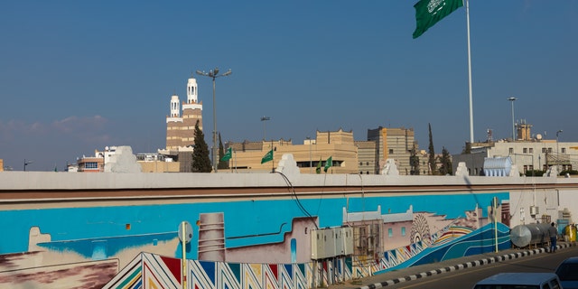 ABHA, SAUDI ARABIA - JANUARY 03: Saudi flag in front of a mural, Asir province, Abha, Saudi Arabia on January 3, 2020 in Abha, Saudi Arabia.  (Photo by Eric Lafforgue/Art in All of Us/Corbis via Getty Images)