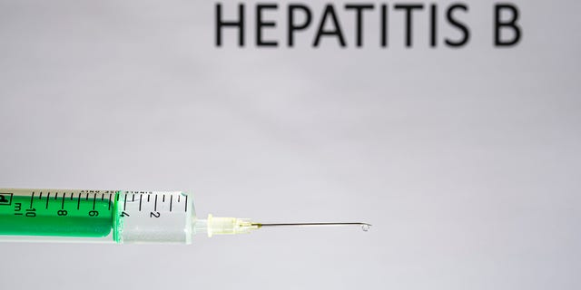 This photo illustration shows a disposable syringe with hypodermic needle, HEPATITIS B written on a white board behind. (Photo Illustration by Frank Bienewald/LightRocket via Getty Images)