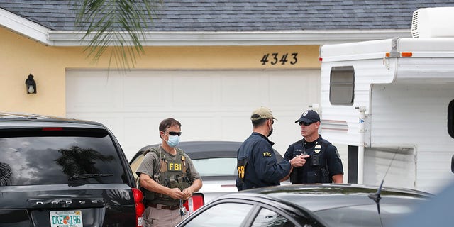 FBI agents talks with a North Port officer while they collect evidence from the home of Brian Laundrie on Sept. 20, 2021 in North Port, Florida. 