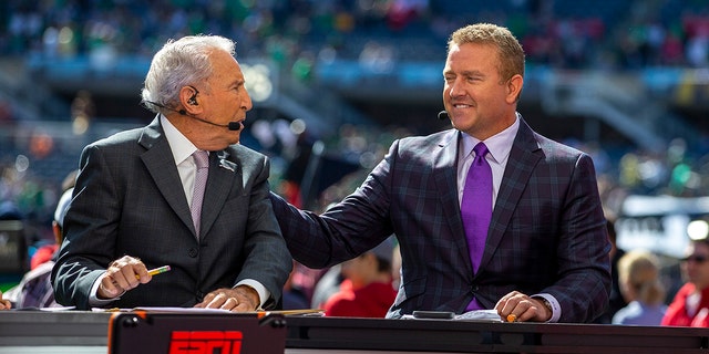 ESPN College Gameday analysts Lee Corso and Kirk Herbstreit talk prior to a game between the Notre Dame Fighting Irish and the Wisconsin Badgers Sept. 25, 2021, at Solider Field in Chicago.