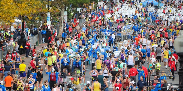 Boston - October 11: Beyond the finish line of the 125th Boston Marathon runners collect their medals, water and emergency blankets in Boston on Oct. 11, 2021.