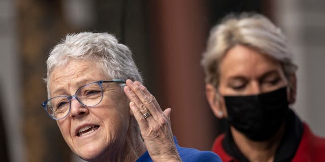 White House National Climate Advisor Gina McCarthy speaks as U.S. Secretary of Energy Jennifer Granholm looks on during an event to discuss investments in the U.S. electric vehicle charging network, outside Department of Transportation headquarters on February 10, 2022, in Washington, D.C.