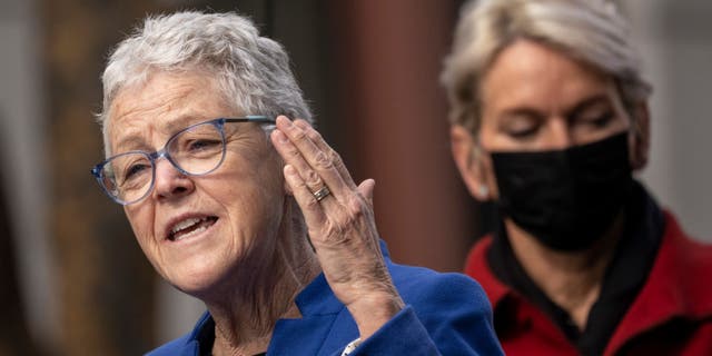 White House National Climate Advisor Gina McCarthy speaks as U.S. Secretary of Energy Jennifer Granholm looks on during an event to discuss investments in the U.S. electric vehicle charging network, outside Department of Transportation headquarters on February 10, 2022, in Washington, D.C.