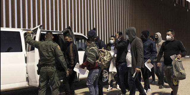 Migrants seeking asylum board a U.S. Customs and Border Protection vehicle to be transferred to temporary shelter in Yuma, Ariz., Feb. 17, 2022. 
