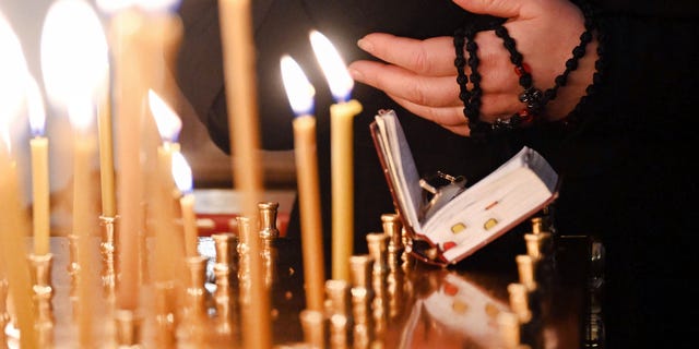 Candles burn during a Russian Orthodox service at Christ the Redeemer Parish on Feb. 27, 2022.