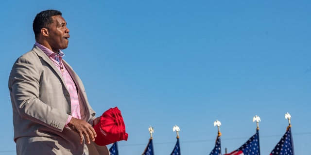 Former Heisman Trophy winner and candidate for Senate Herschel Walker throws hats to supporters of former U.S. President Donald Trump during a rally on March 26, 2022, in Commerce, Georgia.